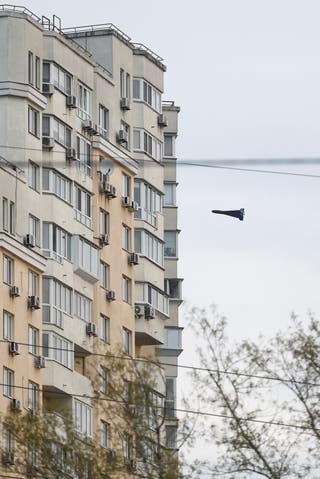 A Russian Geran 2 kamikaze drone flies next to a building amid Russia’s attack on Kyiv